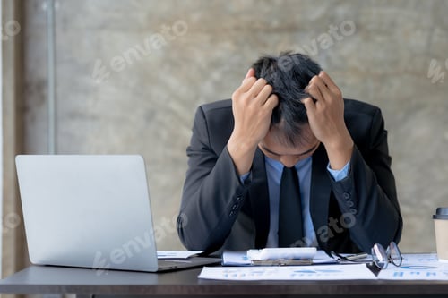 Preview: Asian businessman is stressed and eye strain and tired due to long working day on laptop computer