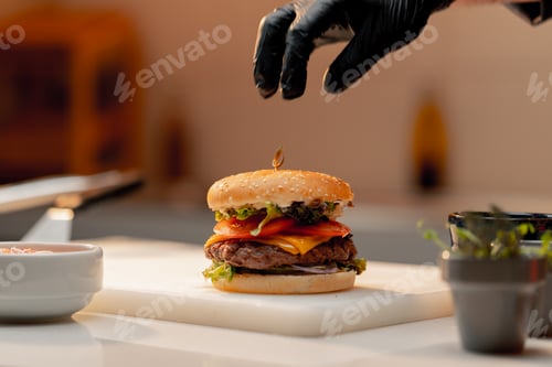 Preview: professional kitchen in a hotel restaurant, close-up of a chef pressing a burger with his hand