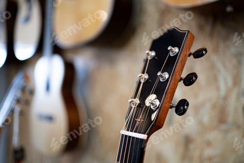 Preview: A guitar headstock is shown with a wall of guitars behind it.
