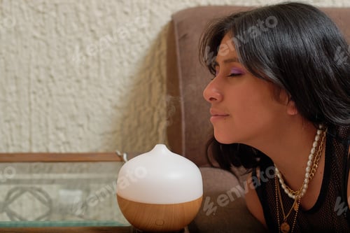 Visualização: Jovem latina usando aromaterapia para relaxar. Conceito de bem-estar.