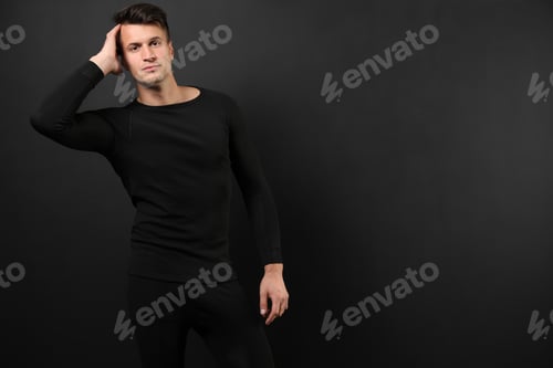 Preview: Man wearing thermal underwear on black background. Space for text