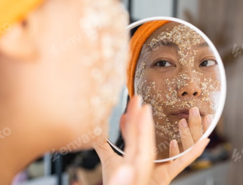 Preview: Portrait of a happy Asian woman using natural secrets for skin care (ingredients on the table: oats,