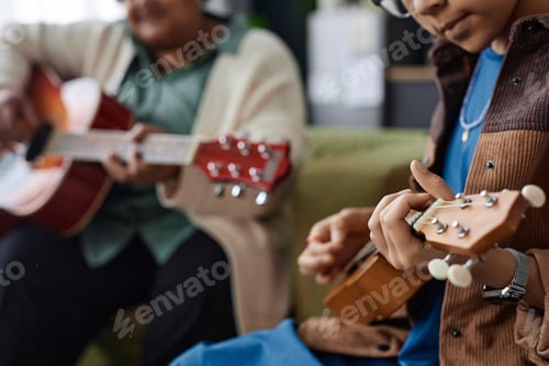 Preview: Close Up of Black Girl Playing Ukulele at Music Class