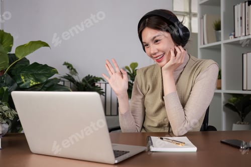 Preview: Asian college student sit at home studying online using a video calling program on their laptop.