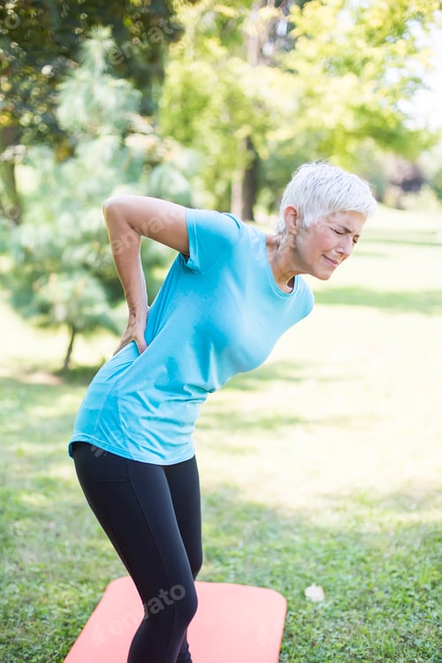 Preview: Sporty senior woman having a back pain