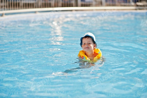 Preview: Boy in panama and child life vest bathes in the pool.