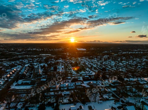 Preview: the sunset is shining over an area with houses and clouds