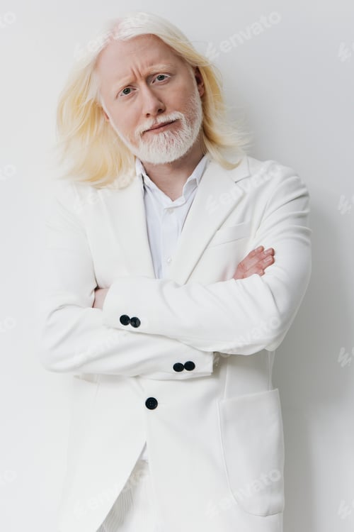 Preview: Professional man in a white suit with long white hair standing confidently against a plain white