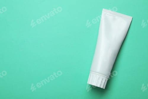 Preview: Blank tube of toothpaste on color background, top view with space for text