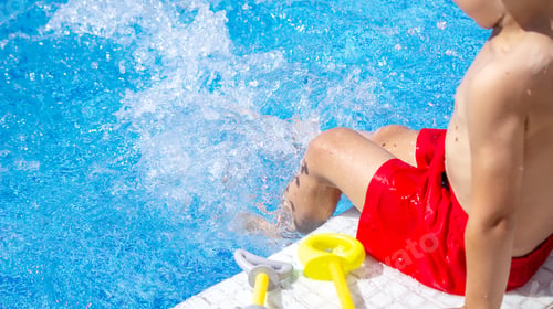 Preview: Happy child in the pool playing with a water gun.