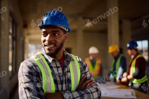 Preview: Confident black worker at construction site looking away.