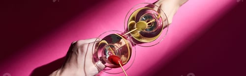 Preview: Cropped view of man and woman holding martini cocktails on pink background, panoramic shot