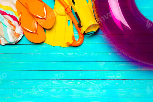 Preview: Summer beach essentials including colorful items on a bright blue wooden surface