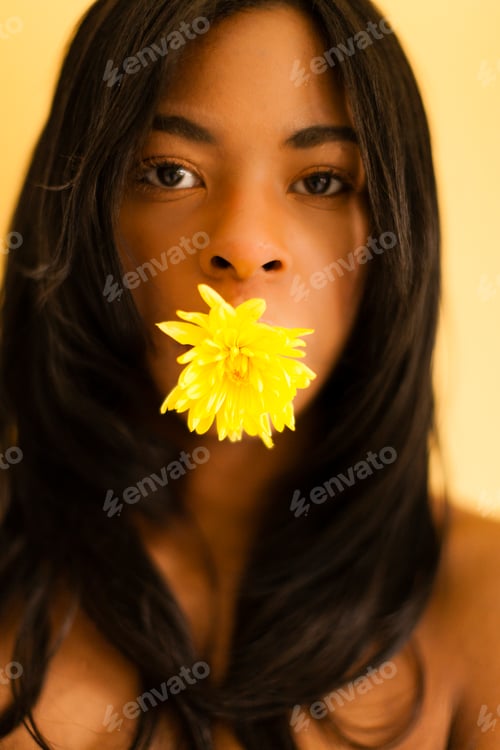 Preview: Young woman posing with flower in her mouth