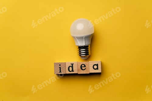 Preview: a yellow warm background without shadows wooden cubes with black letters laid out word idea