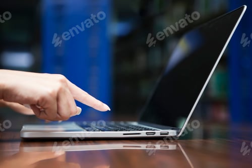 Preview: Business and technology concept. Closeup of hand working with laptop on table.