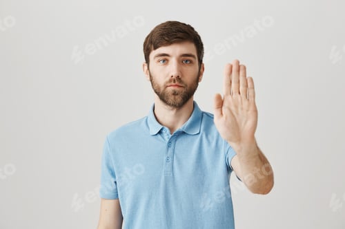 Preview: Body language and emotions concept. Calm and determined caucasian guy showing stop gesture with palm