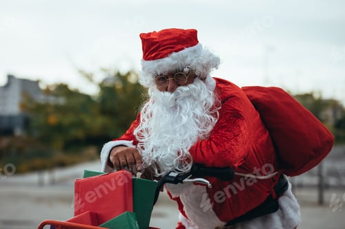 Preview: Santa claus supported in a bicycle full of gifts with exhausted expression. Christmas time