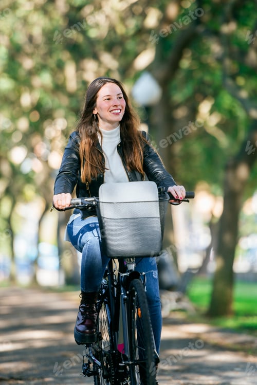 Preview: Woman riding bicycle in park enjoying sunny day