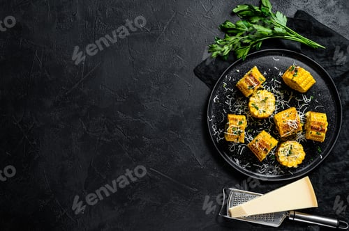 Preview: Grilled corn on cob sprinkled with parsley and grated parmesan. Black background