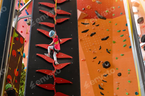 Preview: Child climbing on wall in amusement centre. Climbing training for children.