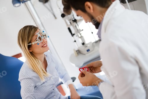 Preview: Woman doing eye test with optometrist in eye sight clinic