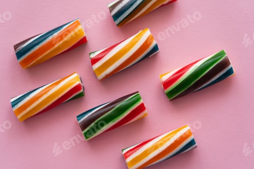 Preview: Flat lay with striped candies on pink background