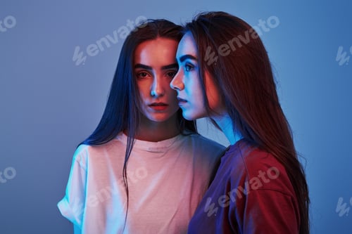 Preview: Handsome people. Studio shot indoors with neon light. Photo of two beautiful twins
