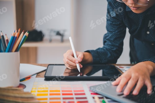 Preview: Graphic designer architects who work with laptops and color comparison tables for design work.