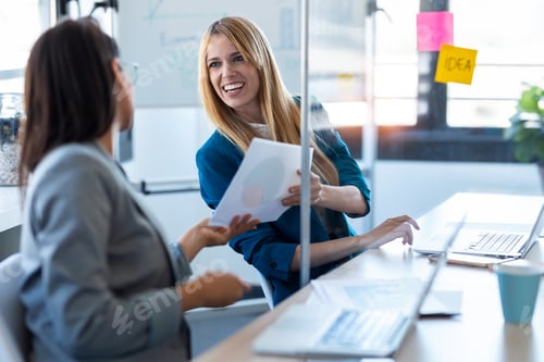 Preview: Two business women passing documents with keeping a distance in the office.