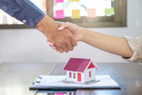 Preview: Real estate agents and buyers handshake after signing a business contract, loan or home insurance