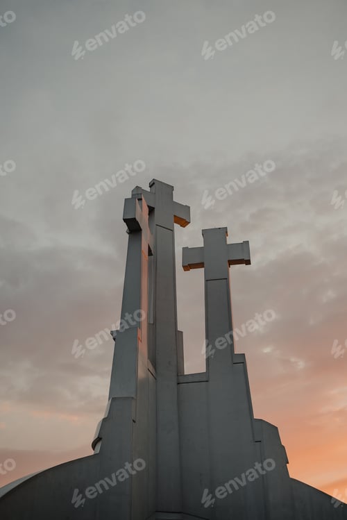 Preview: Vertical low angle shot of the Three Crosses in Vilnius, Lithuania under a colorful sunset sky