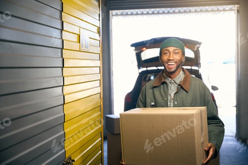 Preview: Man is holding a box in his hands in the storage service