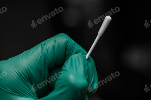 Preview: Closeup of a nurse hand with surgical glove holding a covid test swab