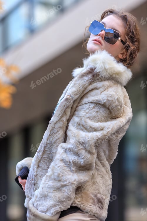 Preview: A young brunette in light warm clothes on the streets of an autumn city.