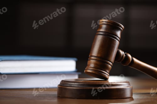Preview: Wooden gavel and books on table against blurred background, closeup