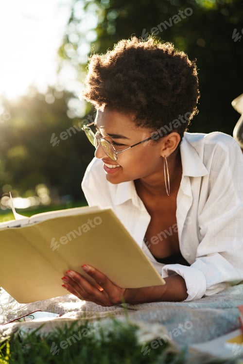 Preview: Smiling african woman lying outdoors