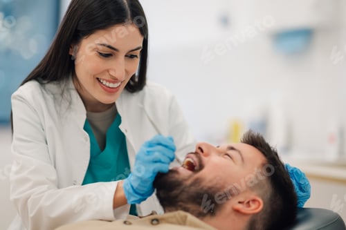 Preview: Female dentist examining patient's teeth in dental clinic