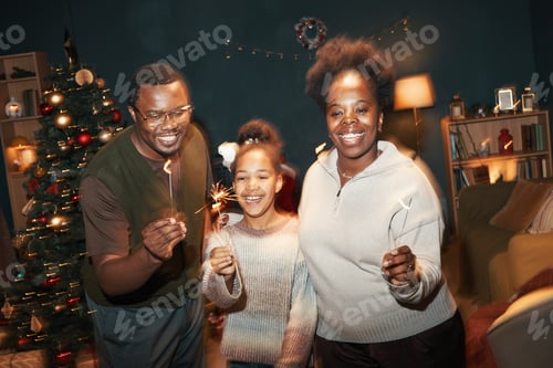Visualização: Retrato de família negra comemorando o Natal segurando estrelinhas dentro de casa