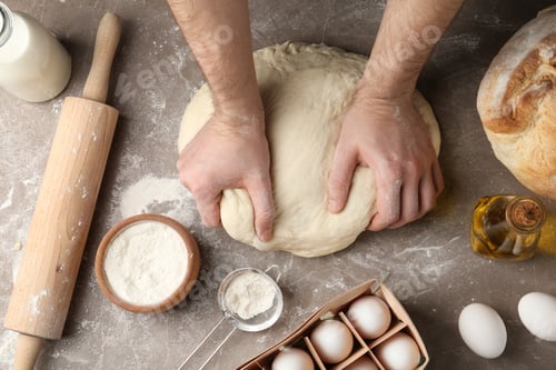 Preview: Male baker preparing bread dough at kitchen table, top view