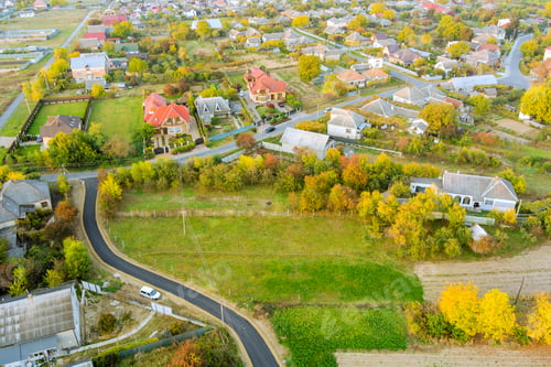 Preview: Scenic view of suburban houses and winding road in a rural landscape during early autumn