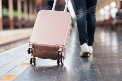 Preview: Tourist walking with rolling suitcase in train station
