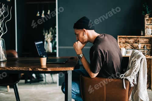 Preview: Young man mobile developer writes program code on a computer, programmer work in home office.