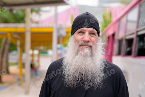 Preview: Face of mature handsome bearded hipster man waiting at the bus stop