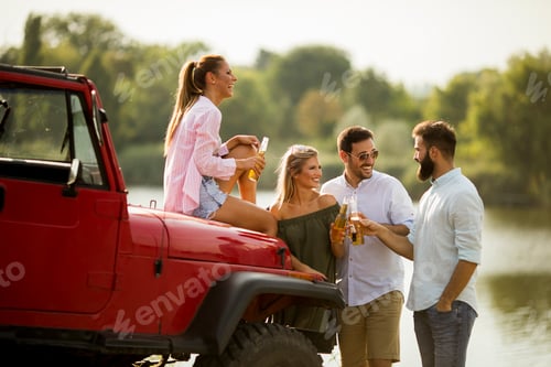 Preview: Young people having fun in convertible car by river