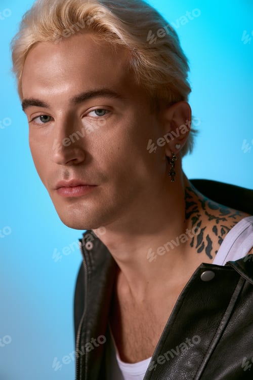 Preview: Handsome young man showcases stylish fashion with confidence in vibrant blue backdrop