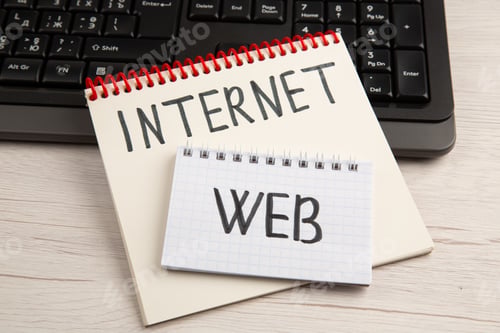 Preview: bottom view web and inernet written on different sizes spiral notepads on keyboard on table