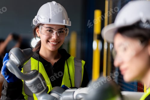 Preview: A team engineers meeting to inspect computer-controlled steel welding robots.