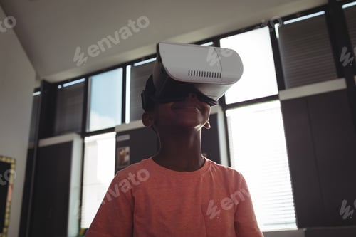 Preview: Low angle view of boy wearing virtual reality simulator