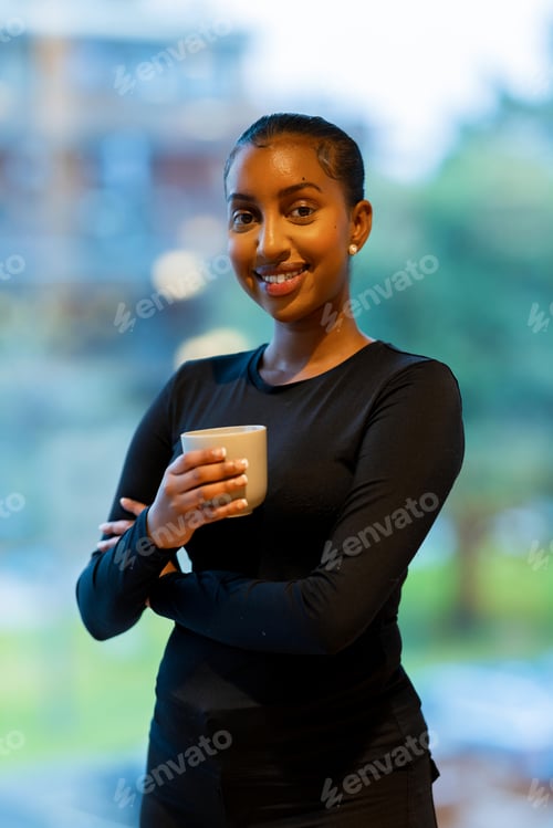 Preview: Woman holding coffee mug indoors